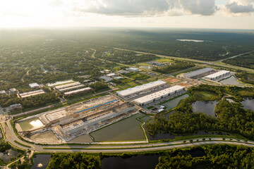 Assembling of metal and concrete frame building at industrial construction site. Commercial real estate market in the USA