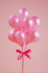 Pink balloons bouquet with ribbon on pink background