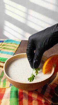 Vertical Video, Brukina, Degue, West Africa Africa Ghana Traditional drink, sweet, beverage made from millet milk and thick