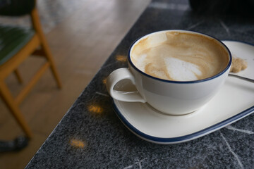 Coffee cup on table with sweet treat nearby