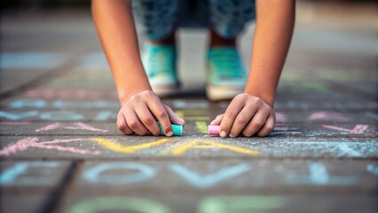 Obraz premium teen community service concept. Child drawing with chalk on pavement, creating colorful patterns.