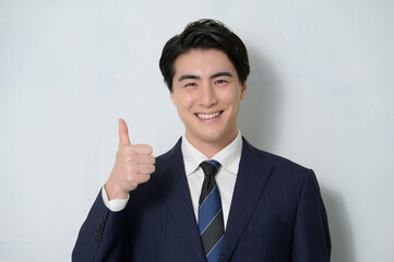 白背景でグッドポーズをする日本人男性