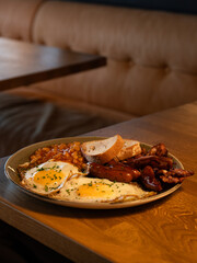 Traditional English Breakfast with Eggs, Bacon, Sausages, and Beans