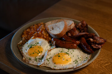 Traditional English Breakfast with Eggs, Bacon, Sausages, and Beans