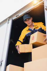 Worker Loading Delivery Boxes into Truck at Warehouse During Daylight for Logistics and Shipping Operations