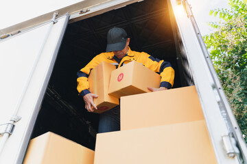 Warehouse Worker Loading Cardboard Boxes into Delivery Truck on Bright Sunny Day