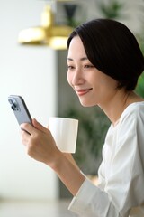 Fototapeta premium カフェでスマホを操作する日本人女性