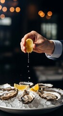 Obraz premium Hand squeezing lemon over fresh oysters on ice platter juice dripping