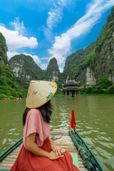 SIAN Woman tourist in boat on the river of the Tam Coc National Park Sightseeing tour to grottoes. Trang An, Ninh Binh, Vietnam.