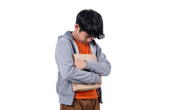 Young person in orange shirt and grey hoodie hugs a brown paper bag