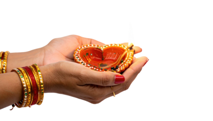 A person holds a lit oil lamp, framed by hands, a symbol of celebration
