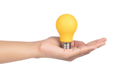 A hand holding a bright yellow lightbulb against a dark background, suggesting idea