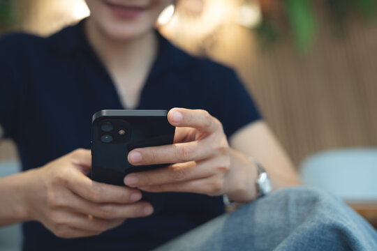 Close up of Young asian woman using smartphone for online shopping and internet banking via mobile app. Smiling woman typing on mobile phone, surfing the net and social media network