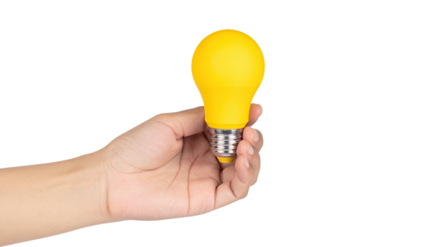 Hand holding a bright yellow illuminated bulb against a stark black background