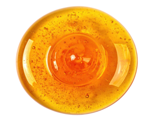 Circular, golden-amber liquid with a raised, central portion, swirling texture