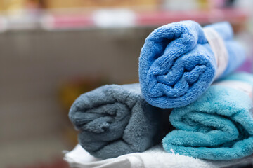 Close-up of Stacked Rolled Terry Cloth Towels in Blue and Grey Tones