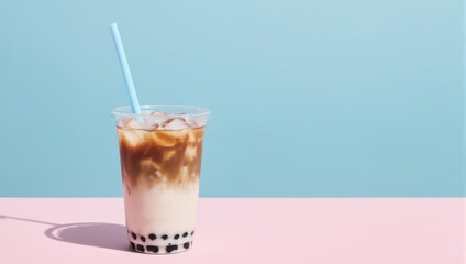 Iced beverage in a clear plastic cup with a blue straw, against a two-toned background