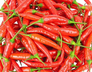 A close-up overhead shot of numerous bright red chili peppers
