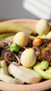 Vertical Video, Ampesie, Traditional Ghanaian Dish of Boiled Yam and Plantain Served with Kontomire Cocoyam Leaves Stew, Avocado, and Eggs, Popular Meal from West Africa