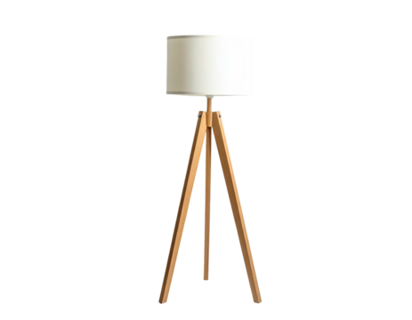 A wooden tripod floor lamp with a cylindrical white shade against a stark black backdrop