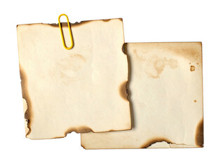 Burned paper notes, held together with a gold-colored paper clip
