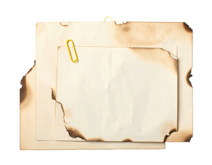 Overlapping, burnt paper sheets, yellow clip, aged appearance on isolated background