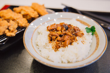 Braised pork rice with crispy fried chicken on sieve served.