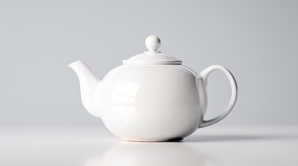 A minimalist white teapot on a smooth surface against a light gray background, showcasing elegant design and simplicity.