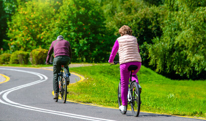 Fototapeta premium Cyclists ride on the bike path in the city Park 