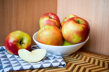Fresh Red and Yellow Apples in Bowl on Wooden Background