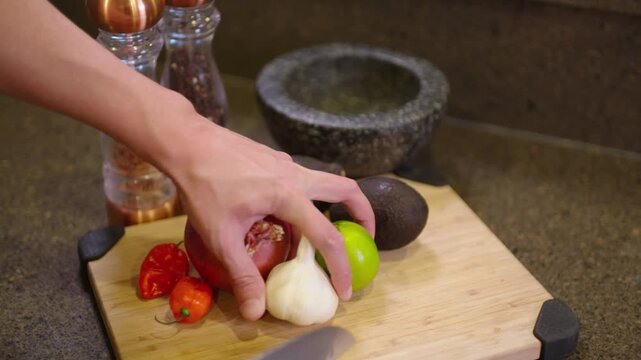 woman cutting vegetables in kitchen for guacamole