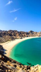 View of a pristine beach with white sand, clear turquoise water