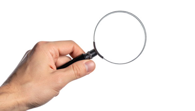 Human hand holding a magnifying glass against a black background
