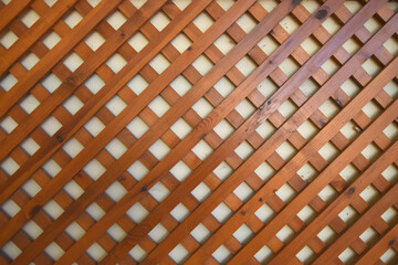 Wooden Lattice Fence Pattern Background. Close-up of brown wooden lattice pattern creating geometric design. Perfect for decor, construction, and design themes.