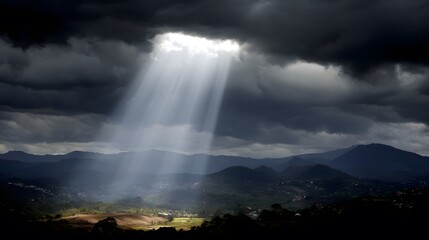 Beam of sunlight breaking through dark storm clouds, illuminating the ground.