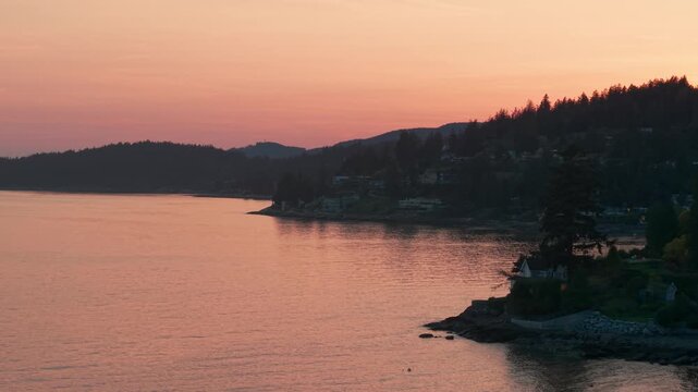 A scenic drone shot of a beautiful sunset over the calm waters in Proctor Avenue, West Vancouver