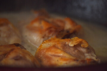 Close-up of baked chicken in oven. Golden roasted chicken close-up with crispy skin, concept of delicious homemade cuisine and cozy meals.