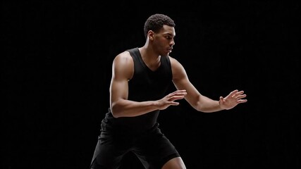 Dynamic African American basketball player in a focused defensive pose. - Powered by Adobe