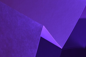 Purple folded paper abstract background. Artistic composition of folded purple paper with soft light and minimal design aesthetic.
