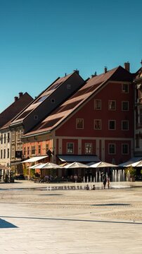 Maribor, Slovenia - August 9, 2025: A timelapse of Maribor&rsquo;s central square (Glavni trg), showing historic facades, the Plague Column, and people walking under bright summer sunlight.