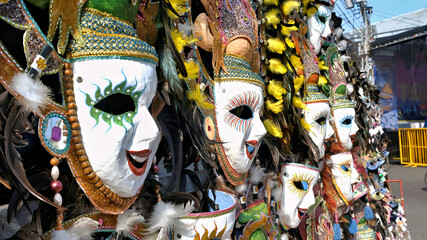 Dynamic Row of Smiling MassKara Festival Masks with Rich Detail and Feathers