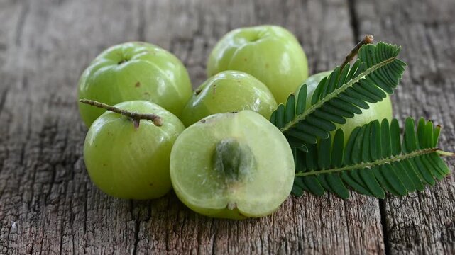 Fresh Amla (Indian gooseberry, Phyllanthus emblica) fruits with leaf on wooden background. herbal medicine plant