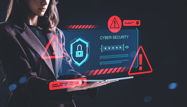 Woman holding tablet with cybersecurity hologram showing warning signs and lock symbol on dark background, representing digital safety concept..