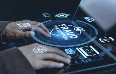Fraud prevention concept hologram interface over hands typing on keyboard illustrating cybersecurity and data protection technologies in action.