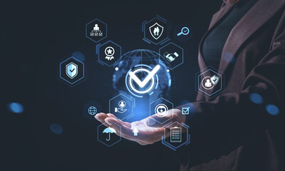 Businesswoman holding hologram with checkmark symbol and digital icons representing quality assurance and compliance concept on dark background.