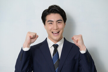 白は背景でガッツポーズをする日本人男性