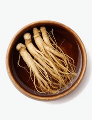 Three ginseng roots in a dark brown bowl