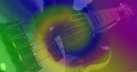 Plucking bassist's hand fretting electric bass guitar steel strings onstage, with colorful lights