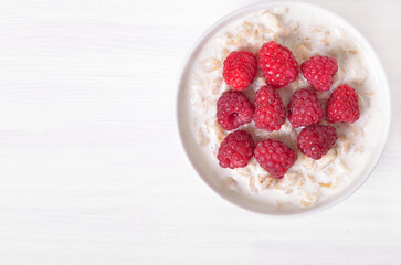Tasty oatmeal porridge with raspberries in bowl