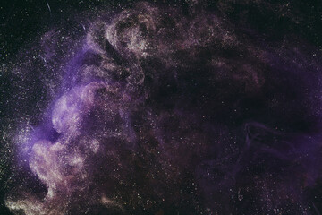 Abstract fluid art background. Moving flow of purple gold paints, dark space sky
